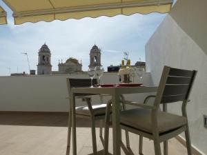 uma mesa de jantar e cadeiras com vista para a cidade em Apartamentos Patagonia Sur em Cádiz
