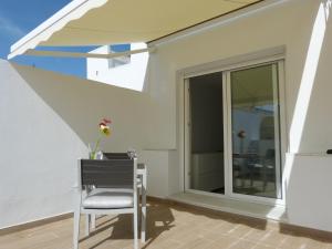 ein Esszimmer mit einem Fenster und einem Stuhl in der Unterkunft Apartamentos Patagonia Sur in Cádiz