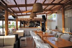 a restaurant with wooden tables and chairs and a bar at Puerto Seaside Rooms in Akhladherí