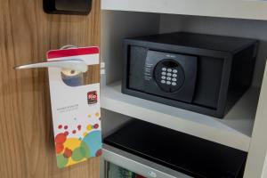 a microwave oven sitting on a shelf next to a box at Rio Hotel by Bourbon Ciudad Del Este in Ciudad del Este