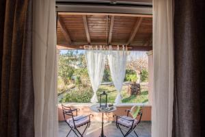 a dining room with a table and chairs in a window at Tellis Holiday Rooms in Moraitika