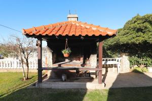 a gazebo with a bench in a yard at Villa Vukic in Vrsi