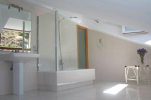a bathroom with a tub, sink and mirror at Hotel el Palacio in Molinaseca