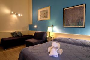 フィレンツェにあるレジデンツァ レ ロンディニのベッド1台、椅子、ソファが備わる客室です。
