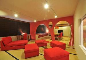 a living room with red furniture and a table at Address Nozawa Suite / Vacation STAY 22748 in Nozawa Onsen