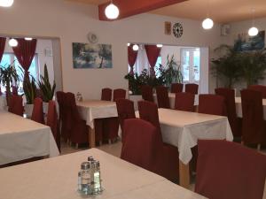 a dining room with tables and chairs in a room with plants at House Šapina in Korenica