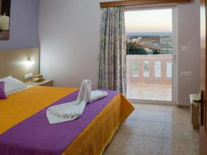 1 dormitorio con cama y ventana grande en Margarita Αpartments Sea View, en Palaiochóra