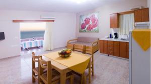 a kitchen and dining room with a table and a room with the ocean at Margarita Αpartments Sea View in Palaiochóra