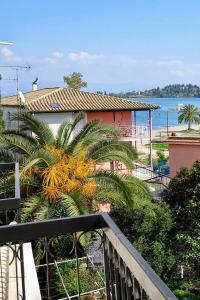 balcón con vistas a la playa y a una casa en Hotel Orpheus en Gouvia