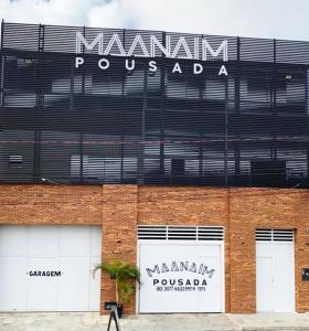 a building with a sign on the side of it at Pousada Maanaim in Campina Grande
