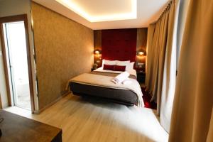 a bedroom with a bed with a red headboard at Hercules Boutique Hotel in Ceuta