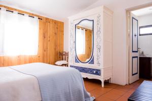 een slaapkamer met een wit bed en een spiegel bij Carrança Lounge in Évora