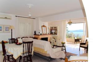 a living room with a bed and a table and chairs at Atena Mare Sea View in Perama