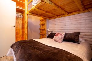 a bed in a room with a wooden wall at Lotto in Sierra Nevada