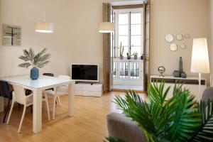 a living room with a white table and a living room with a tv at INMálaga Fresca II in Málaga