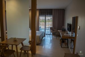 um quarto de hotel com uma cama, uma mesa e cadeiras em Double Bay Beach Hotel em Elafonisos