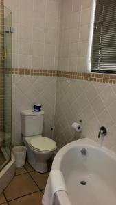 a bathroom with a toilet and a bath tub at C-Rus in Strand +14 photos