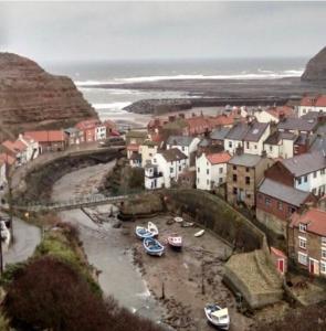 a small town with boats in the water at The Royal George Staithes in Staithes +22 photos