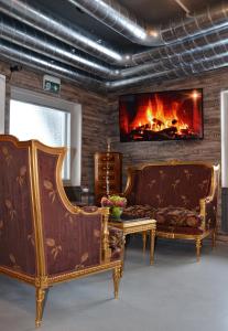 a living room with two chairs and a fireplace at Loft Family Hotel in Imatra