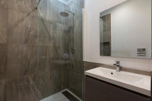 W łazience znajduje się prysznic, umywalka i lustro. w obiekcie Clementi Portrait w Rzymie