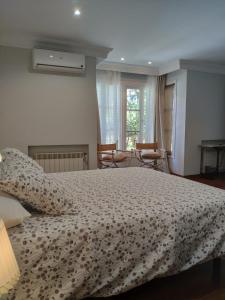 a bedroom with a bed and two chairs in it at Villa Antumalal B&B in Málaga