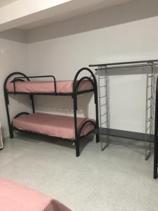 a room with two bunk beds with pink sheets at Cheap Stop in Pompei