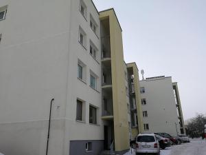 a white building with cars parked in a parking lot at Buto nuoma šviesos gatvėje in Telšiai