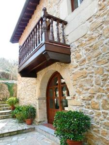 AbanillasにあるLa Posada de Abanillasの木製のドアとバルコニー付きの建物