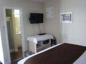 Habitación pequeña con cama y TV. en Paddock Inn, en Coleman