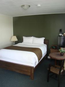 a bedroom with a large bed with a green wall at Paddock Inn in Coleman