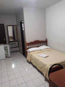 ein Schlafzimmer mit einem Bett und einem Handtuch darauf in der Unterkunft Hotel Nolasco in Macaé