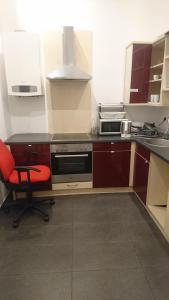 a kitchen with a stove and a red chair at ABAI Apartments 1150 only WWW-On-line-Check-in & SelfService in Vienna