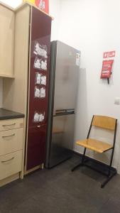 einen Kühlschrank in einer Küche mit einem Stuhl daneben in der Unterkunft ABAI Apartments 1150 only WWW-On-line-Check-in & SelfService in Wien