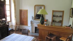 a living room with a fireplace and a lamp on a table at Chambres d'Hôtes Les Tapies in Agen dʼAveyron