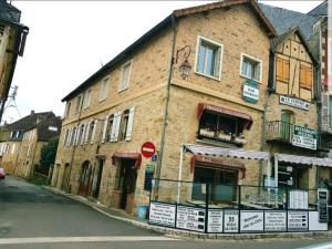 um velho edifício de tijolos ao lado de uma rua em La chambre des cht'is em Vayrac
