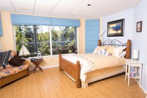 a bedroom with a bed and a large window at Madeira Park Oceanview Suites in Madeira Park