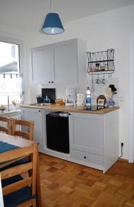 a kitchen with white cabinets and a black dishwasher at Deine Ferienwohnung in Falkenstein
