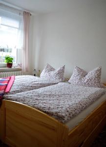 a bedroom with a large bed with pillows on it at Deine Ferienwohnung in Falkenstein