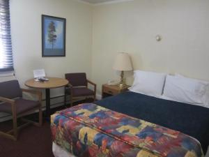 a hotel room with a bed and a table and chairs at Big Horn Motel in Buffalo
