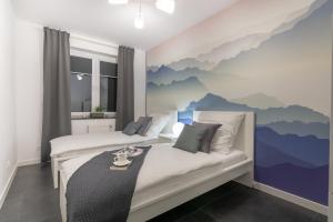 a bedroom with two beds with a mountain mural on the wall at Apartamenty Cisza - Ustrzyki Dolne noclegi - Bieszczady noclegi in Ustrzyki Dolne