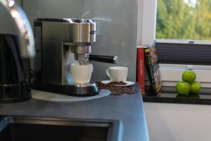 a coffee maker and two cups on a counter at Apartamenty Cisza - Ustrzyki Dolne noclegi - Bieszczady noclegi in Ustrzyki Dolne