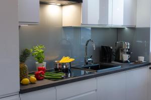 a kitchen counter with a sink and fruits and vegetables at Apartamenty Cisza - Ustrzyki Dolne noclegi - Bieszczady noclegi in Ustrzyki Dolne