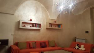 a living room with a red couch and a chandelier at B&B Alassio in Alassio