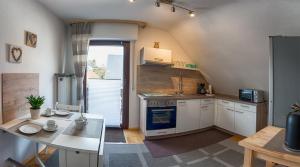 a kitchen with white cabinets and a table and a stove at Ferienwohnung Maria Laach 2 in Glees