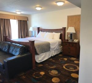 Stonebridge Hotel في فورت ماكموري: غرفه فندقيه بسرير واريكه