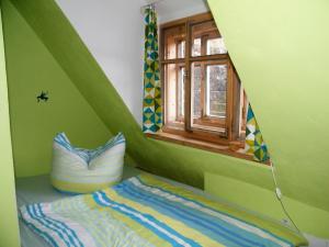 a room with a green room with a bed and a window at Ferien im Denkmal an der Elbe in Stadt Wehlen