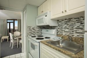 a kitchen with a sink and a stove top oven at Grande Shores Ocean Resorts Condominiums in Myrtle Beach