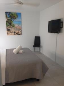 a bedroom with a television and a bed at Chez Noosa Resort Motel in Sunshine Beach