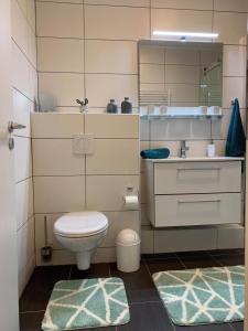 a bathroom with a toilet and a sink at Mariposa inclusive Pool und Sauna in Bad Harzburg