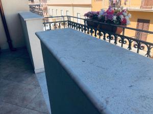 a bench on top of a balcony with flowers at Sicilia Vacation rooms in Trapani